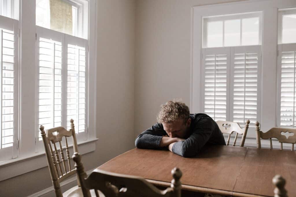 Homme désespéré et malsain assis à table